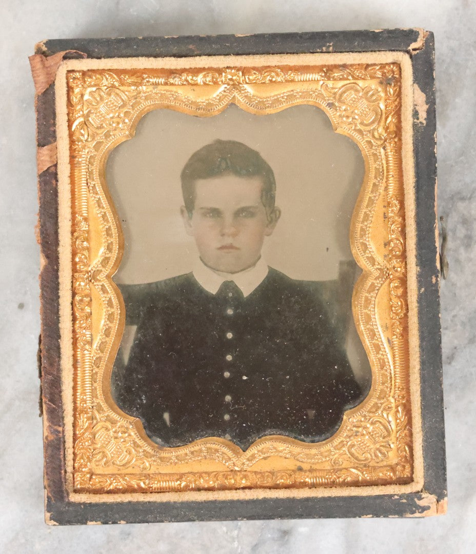 Lot 058 - Antique 1/9th Plate Ruby Ambrotype Photograph Of Stern Looking Young Boy With Tinted Details, In Split Half Leatherette Union Case