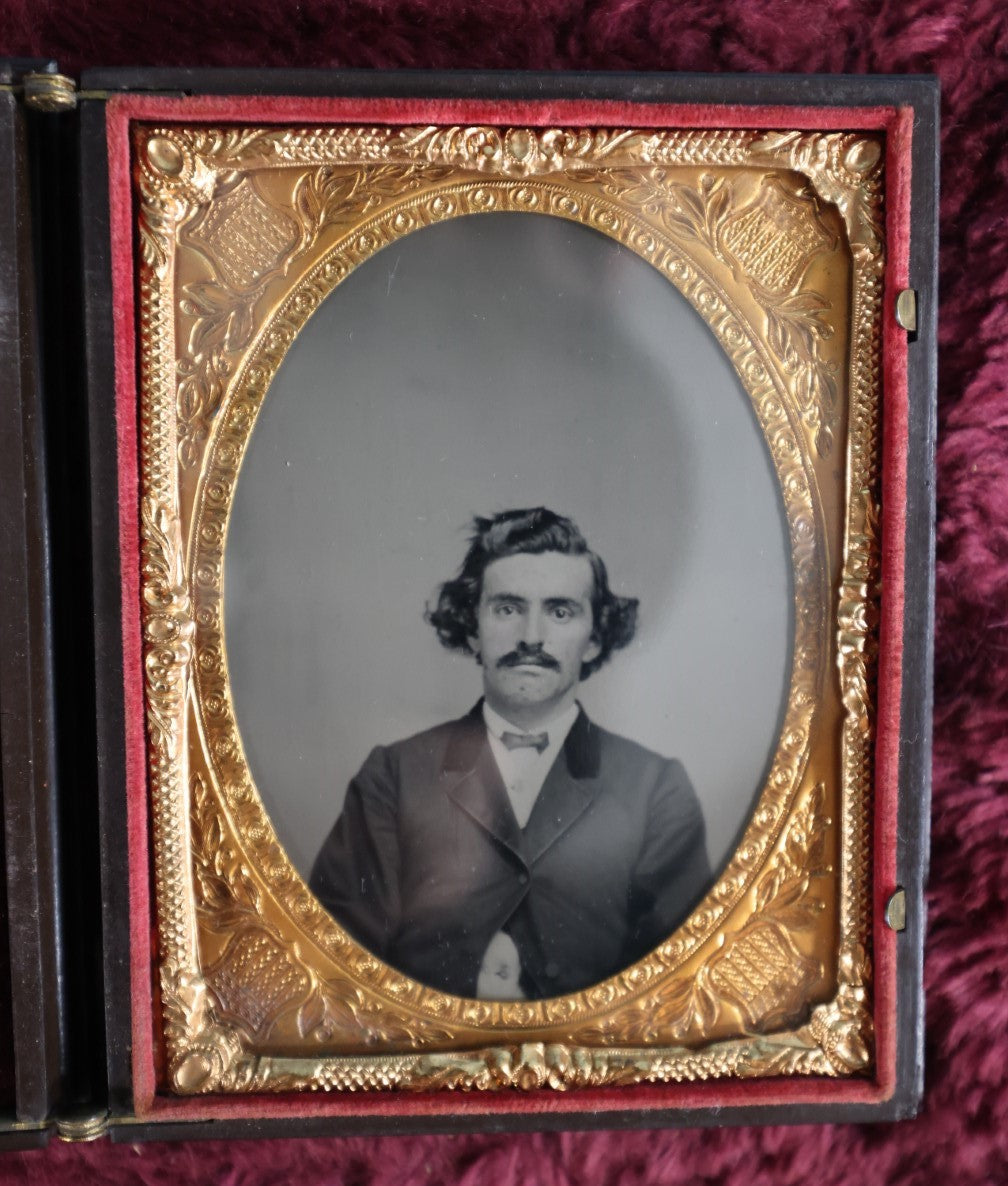 Lot 161 - Quarter Plate Ambrotype Of Handsom Young Man With Interesting Look, Mustache, Unusual Headroom Framing, Near Perfect Condition Large Size Thermoplastic Case With Lay Flat Hinge, Patriotic Shield Brass Mat