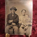 Lot 117 - Tintype - Couple, Man And Woman, Woman Holding Child, Motion Blur In Child's Face, Man Wearing Hat And Of Possible Native Ancestry