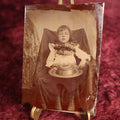 Lot 121 - Tintype - Upset Looking Young Girl Sitting In Chair With Wide Hat In Her Lap, Large Bow