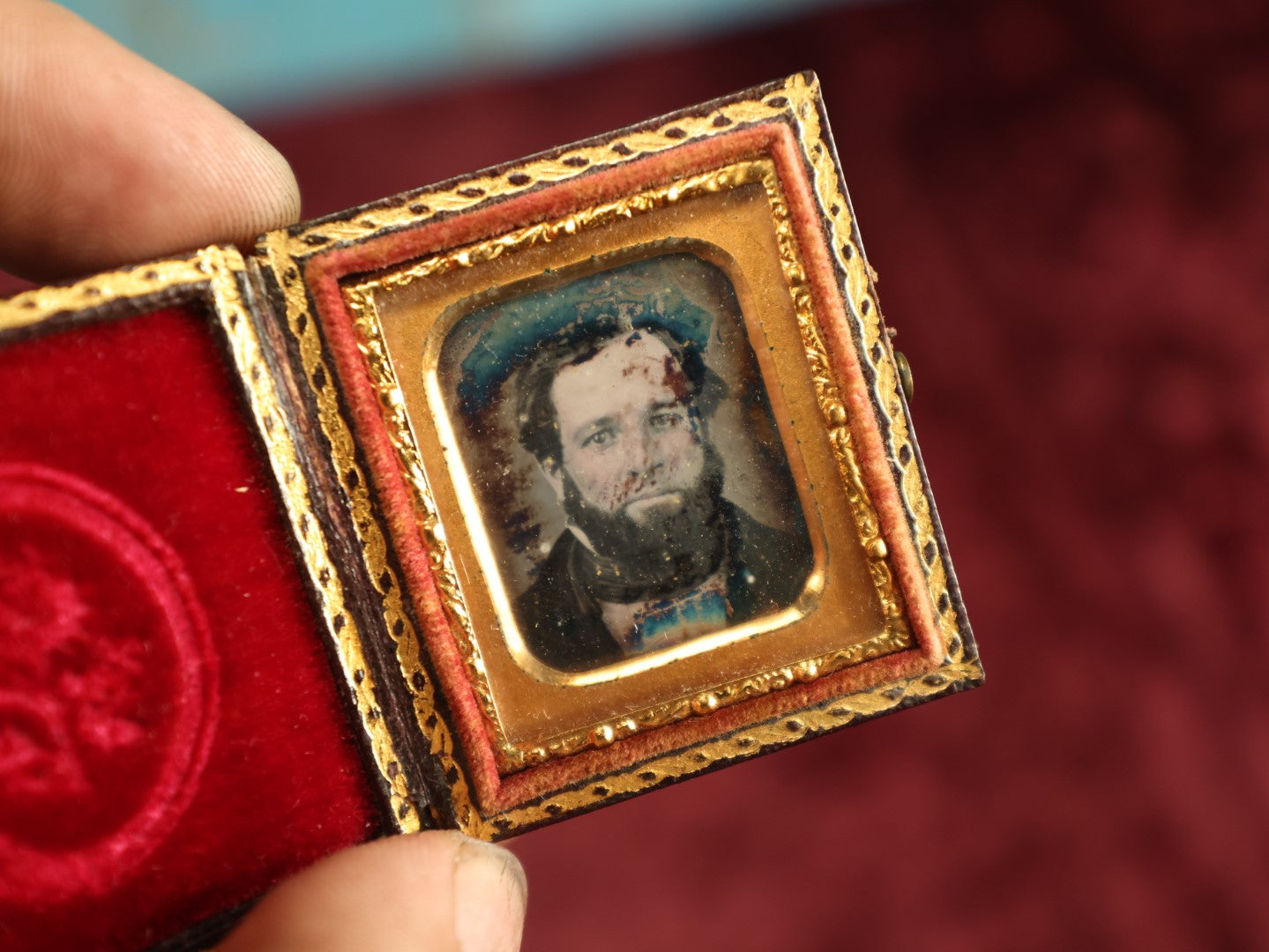 Lot 035 - Antique 1/16th Plate Daguerreotype Photograph In Intact Case Of Man With Beard, Flower On Red Pillow, Heavy Wear