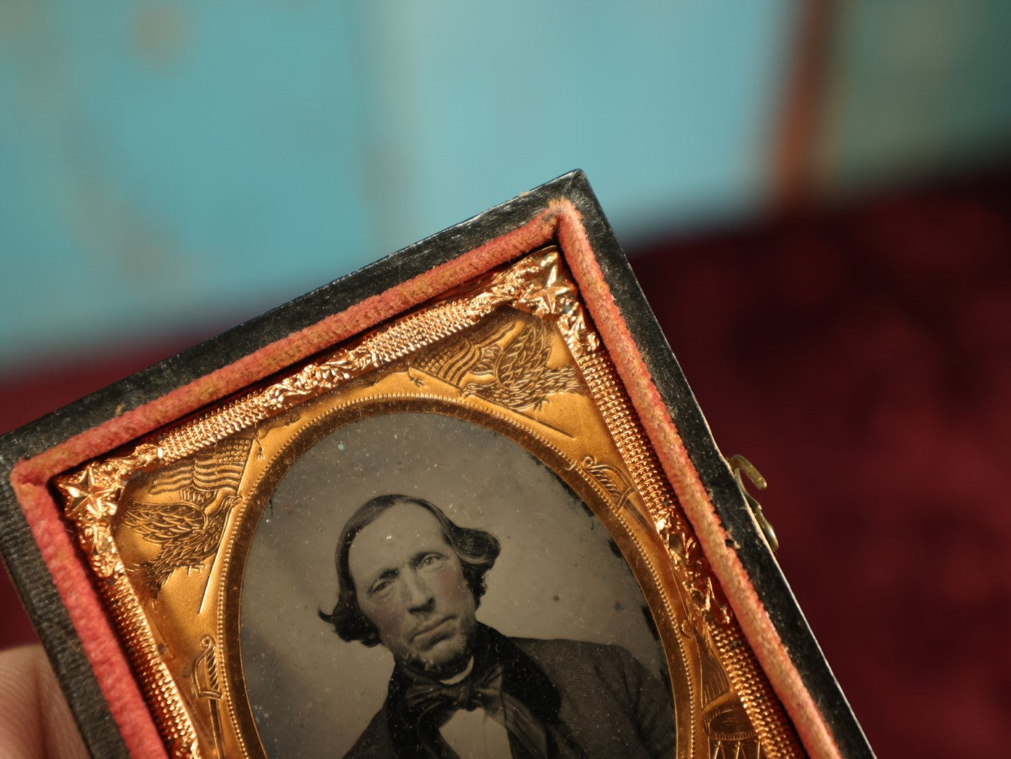 Lot 036 - Antique 1/9th Plate Ruby Ambrotype Photograph With Patriotic, Civil War Brass Mat With Eagle Carrying Flag, Drum, Canon, Rifle, Sword, Photo Of Man With Bowtie, Full Split Case