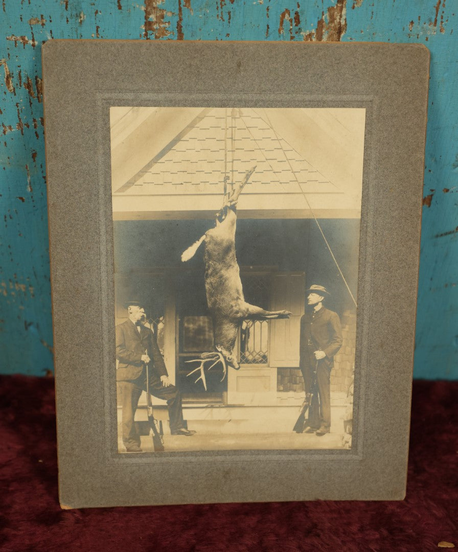 Lot 105 - Single Boarded Photo Of Deer Buck Strung Up, Hunters Look On Holding Rifles