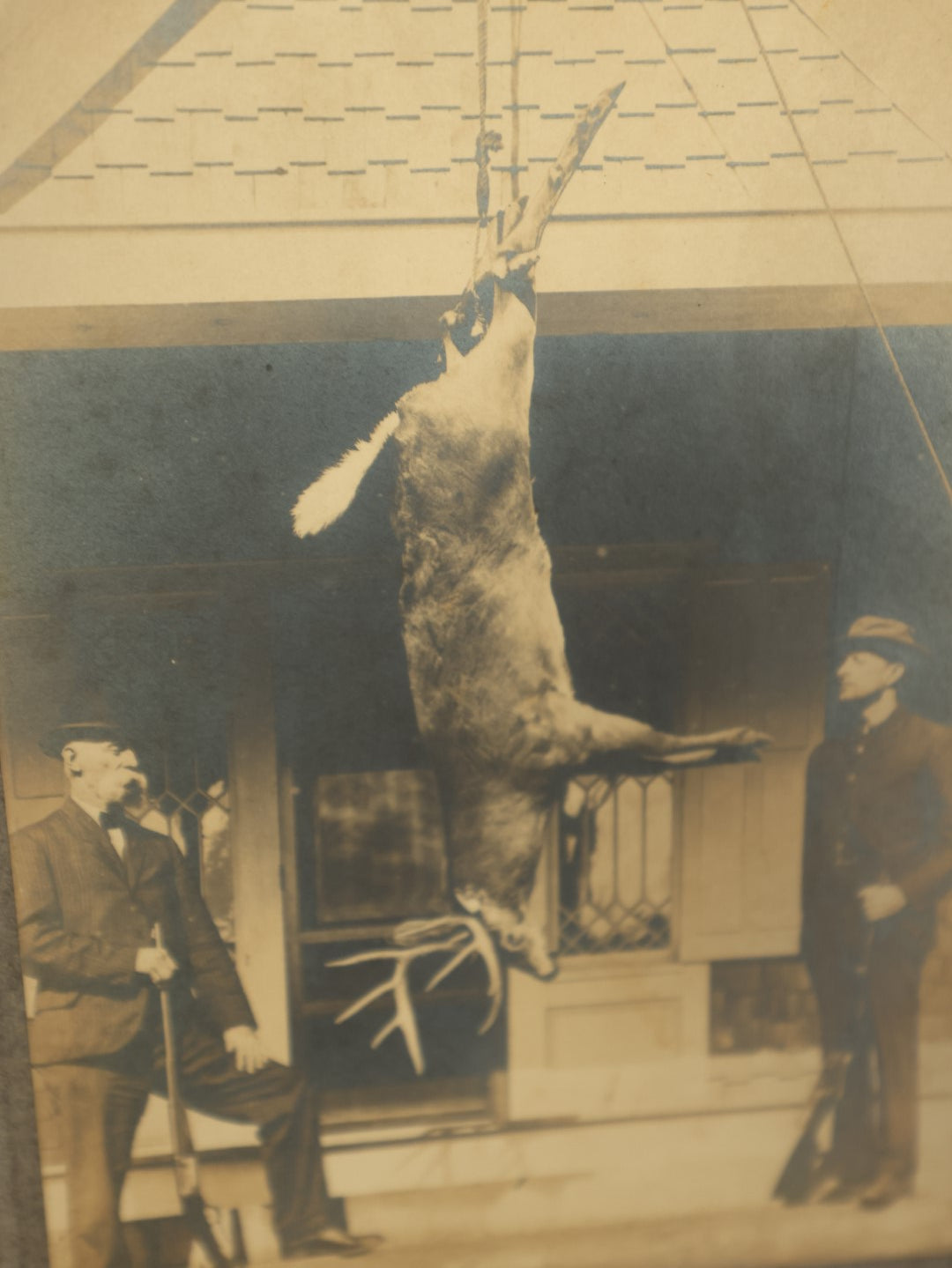Lot 105 - Single Boarded Photo Of Deer Buck Strung Up, Hunters Look On Holding Rifles