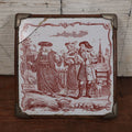 Lot 077 - Antique Painted Tile In Frame Trivet / Wall Hanger, Street Scene With Man, Baby, Pig, Dog, Church And Cemetery In Background, Note Severe Damage, Repairs