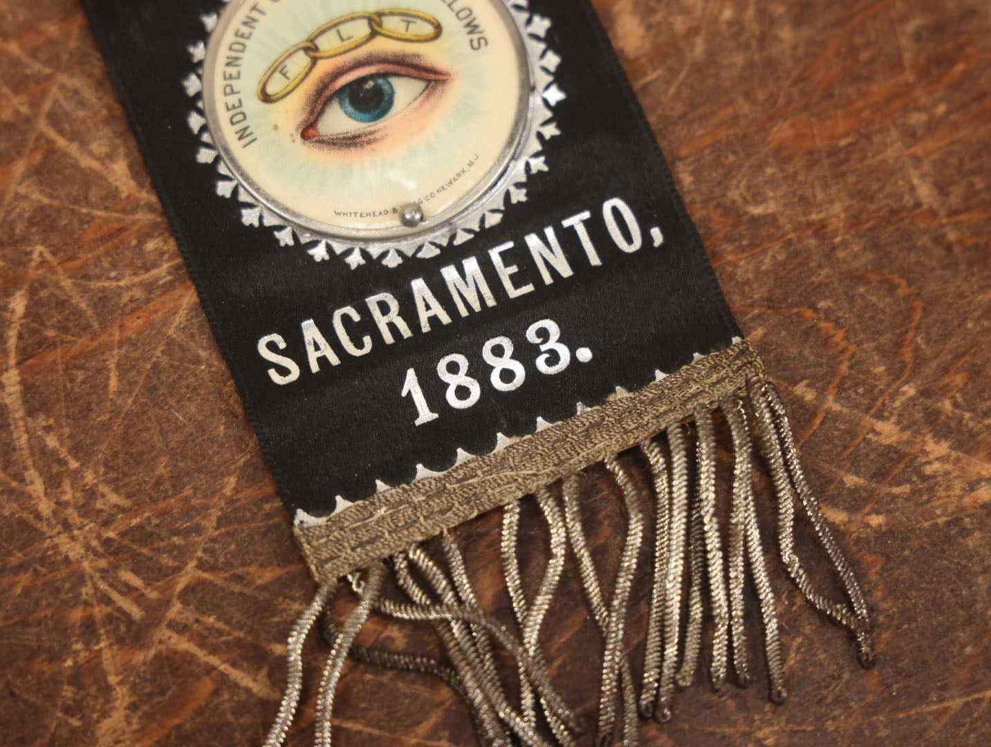 Lot 040 - Antique Odd Fellows I.O.O.F. Veteran Odd Fellows Association Ribbon And Badge, Sacramento, 1883, With All Seeing Eye, Three Links, F.L.T., By The Whitehead & Hoag Co., Newark, New Jersey