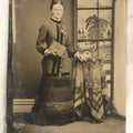 Lot 099 - Single Antique Tintype Photograph, Woman Standing In Front Of Faux Window With Country Scene, Holding Book