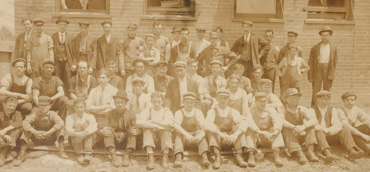 Lot 024 - Antique Boarded Occupational Photograph Of A Group Of Laborers Outside Of A Commercial Building, Note Ladies In Window, Striped Awnings