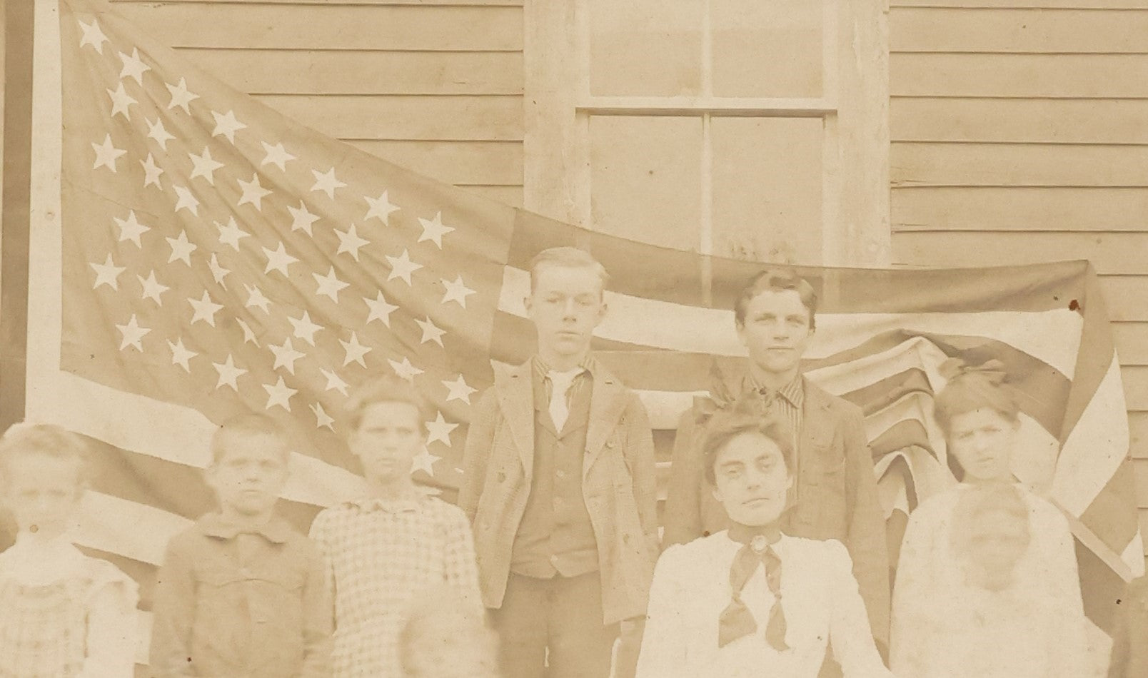 Lot 030 - Antique Boarded Photograph Of A Woman And Children In Front Of As 48 Star American Flag, Early 20th Century, Little Girl Identified As Teresa Heyes
