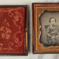 Lot 096 - Antique 1/6th Plate Daguerreotype Photograph Of A Young Boy In A Polka Dot Shirt And Checkered Pants, Resting Arm On Table With Paisley Drapery, In Seperated Complete Leatherette Case
