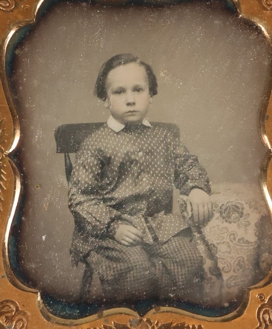 Lot 096 - Antique 1/6th Plate Daguerreotype Photograph Of A Young Boy In A Polka Dot Shirt And Checkered Pants, Resting Arm On Table With Paisley Drapery, In Seperated Complete Leatherette Case