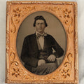 Lot 107 - Antique 1/6th Plate Ambrotype Of A Steely Eyed Young Man In A Suit And Bowtie Holding A Thermoplastic Photo Case In Lap, Note Crazing To Ambrotype Black Paint Backing, No Case
