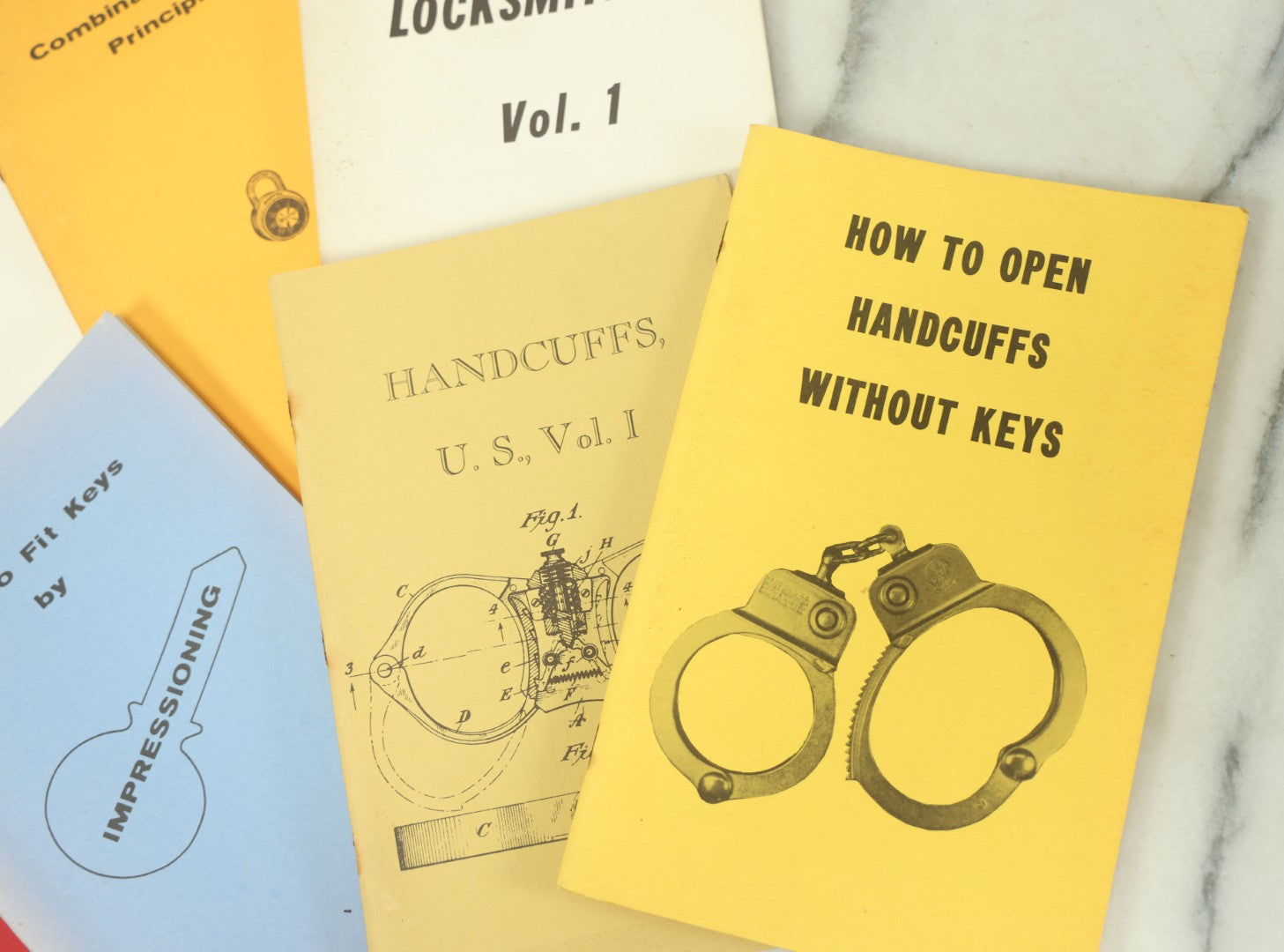 Lot 094 - Grouping Of Seven Booklets On Handcuffs And Locksmithing, Including How To Open Handcuffs Without Keys, Lock Picking, Etc., By Desert Publications, Late 1970s