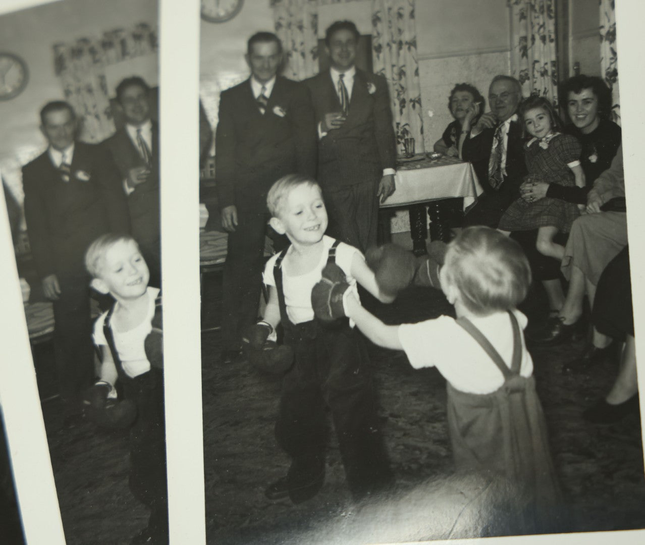 Lot 116 - Grouping Of Four Identical Snap Shot Photographs Of Two Young Boys Play Boxing With Gloves While Amused Family Members Look On