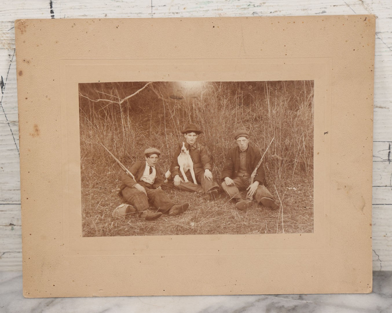 Lot 106 - Antique Boarded Photo Of Three Young Men Hunting With Rifles, With Hunting Dog In Photo, Sitting On Ground, Identified