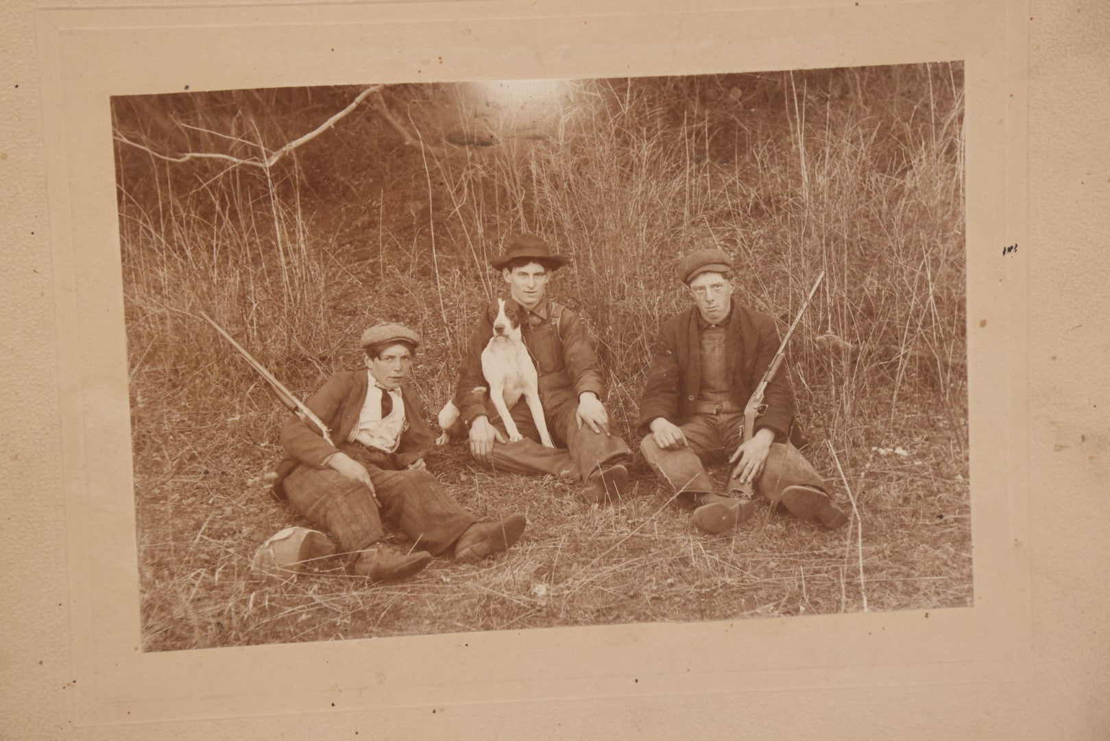 Lot 106 - Antique Boarded Photo Of Three Young Men Hunting With Rifles, With Hunting Dog In Photo, Sitting On Ground, Identified