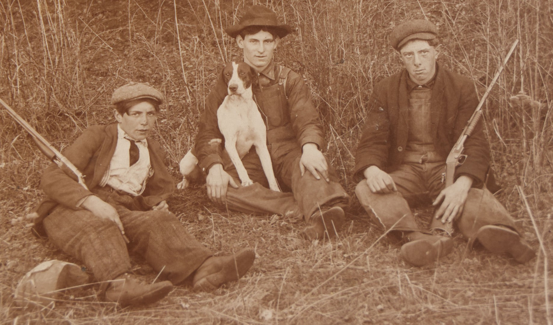 Lot 106 - Antique Boarded Photo Of Three Young Men Hunting With Rifles, With Hunting Dog In Photo, Sitting On Ground, Identified