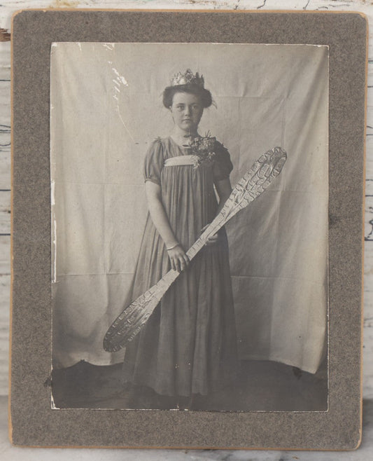 Lot 108 - Antique Boarded Photo Of A Young Woman In A Crown Holding A Silvery Foil Covered Paddle, Unknown Occasion
