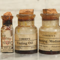 Lot 075 - Grouping Of 7 Antique Glass Bottles For Artists Supplies, Including Tinting Oil, Oil Anise, Lustre, And Others, As Found, Various Manufacturers