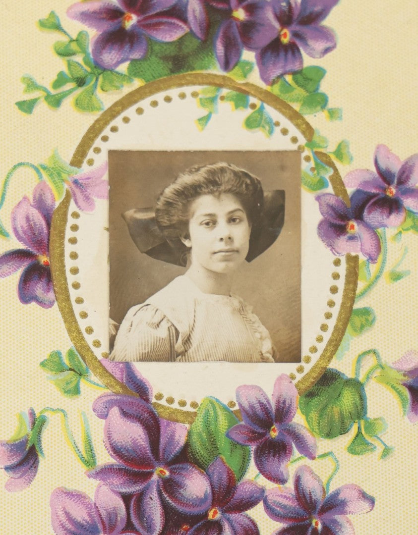 Lot 104 - Single Antique Postcard With Clipped Photo Of Young Woman With Large Bow, Purple Flower Design, Signed On Verso