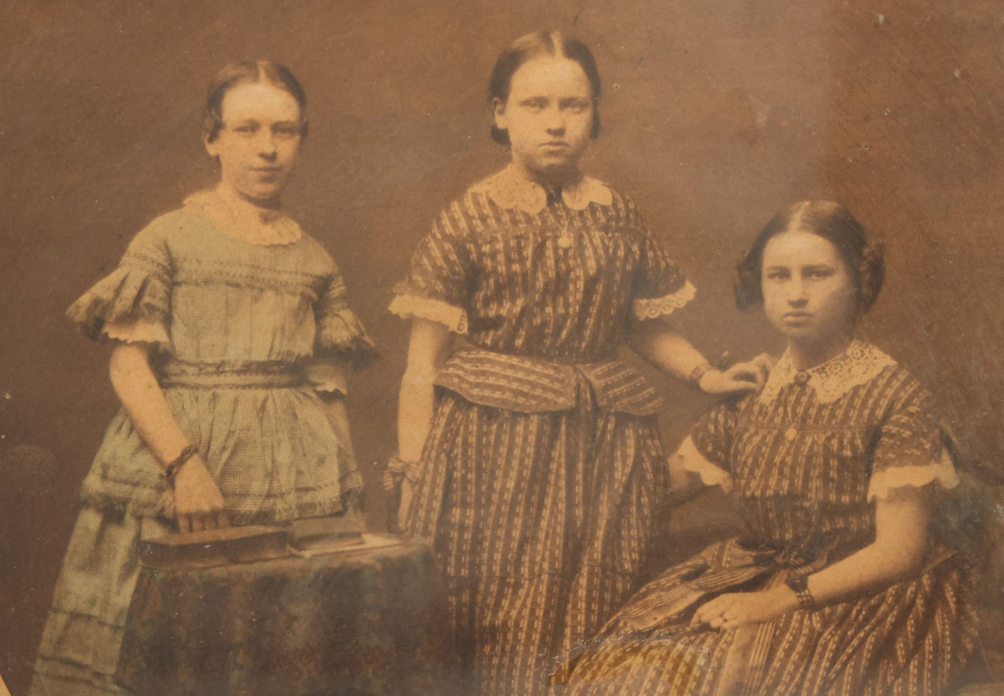 Lot 078 - Antique Framed Hand Tinted Photograph Of Three Young Girls, Likely Sisters, In Dresses, I.D. In Pencil On Verso