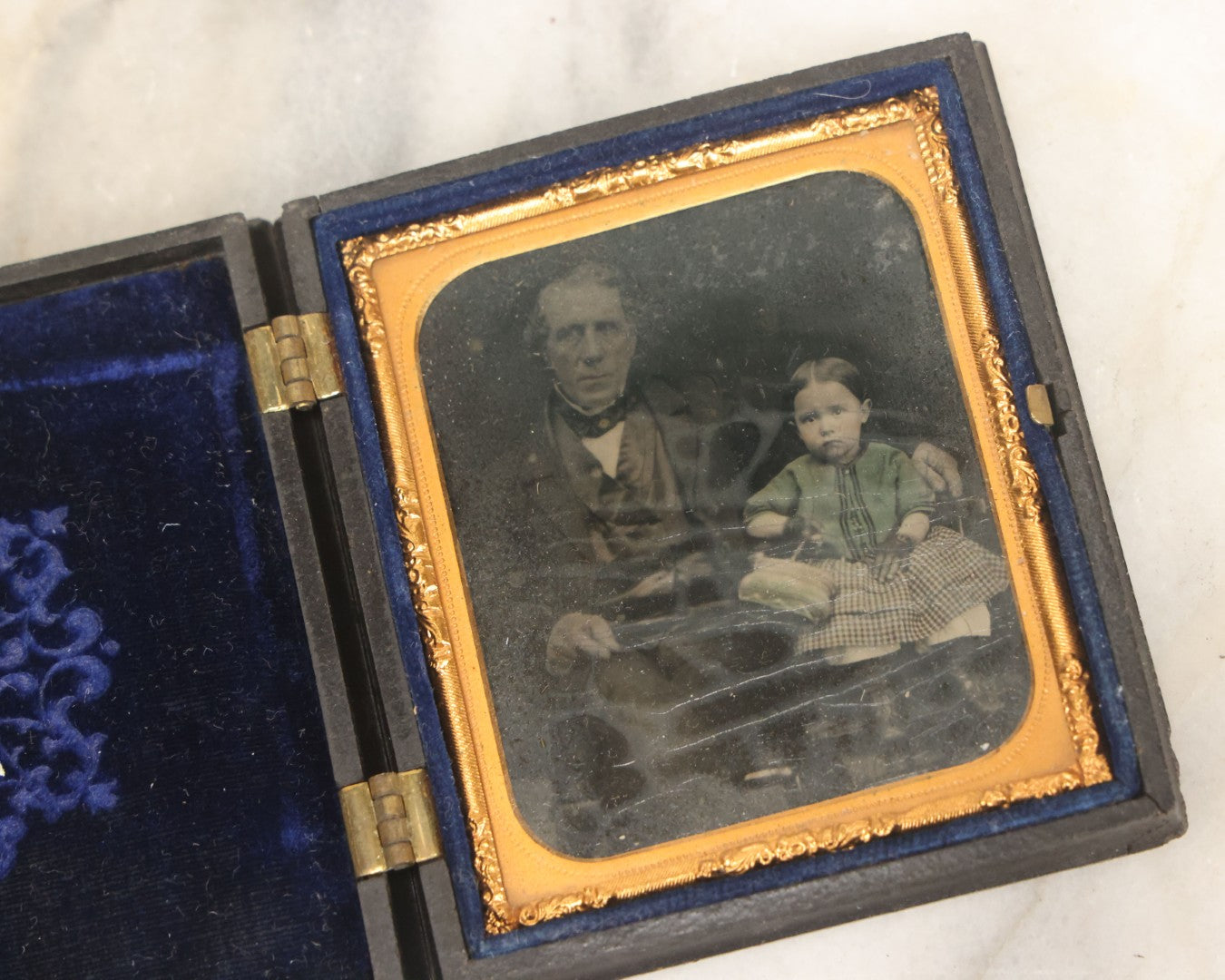 Lot 081 - Antique 1/6th Plate Tintype Photograph Of A Grandfather And Grand Daughter In Hand Tinted Green Dress, In Thermoplastic Union Case With Naval Ship Motif, Flag
