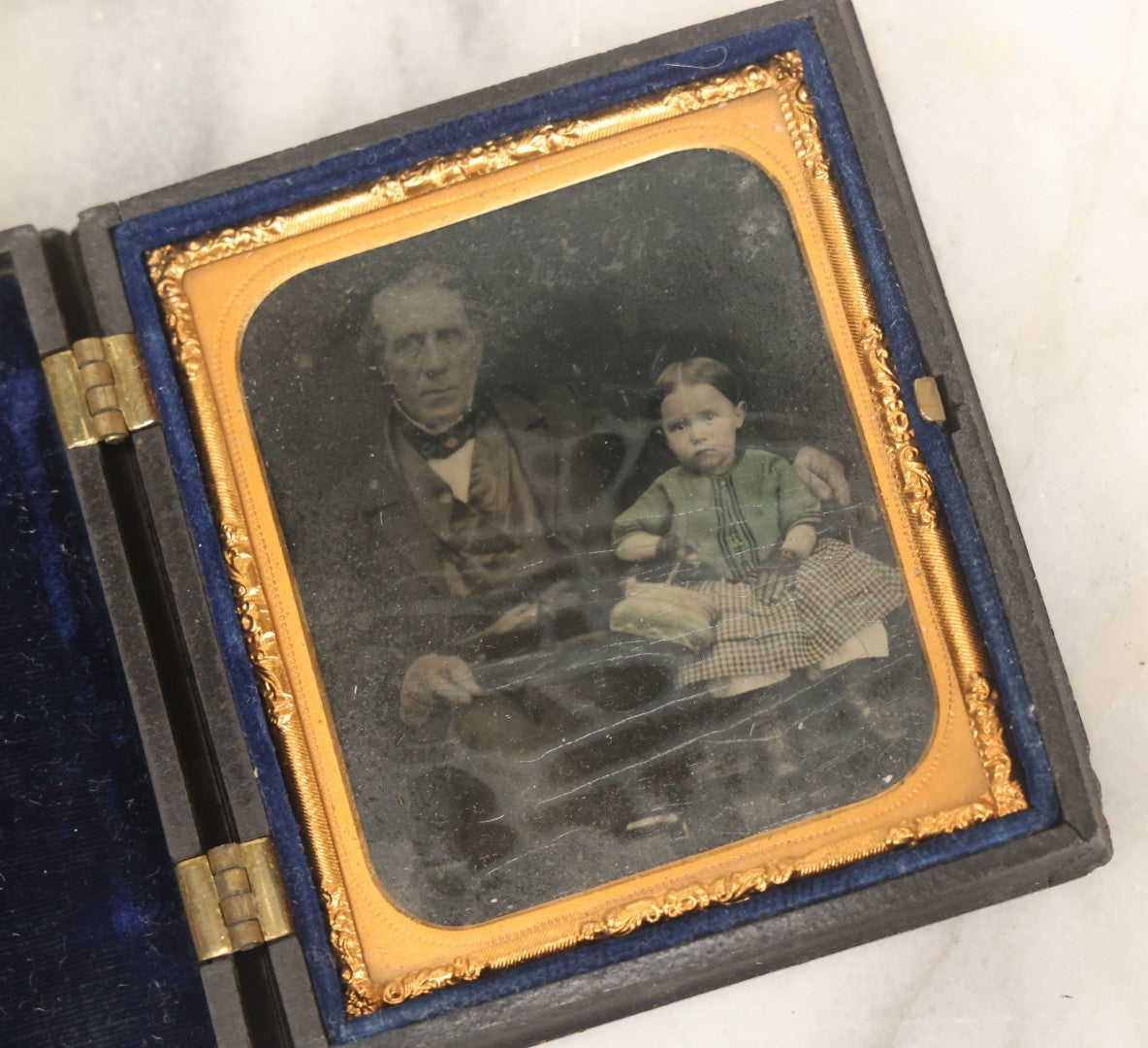 Lot 081 - Antique 1/6th Plate Tintype Photograph Of A Grandfather And Grand Daughter In Hand Tinted Green Dress, In Thermoplastic Union Case With Naval Ship Motif, Flag