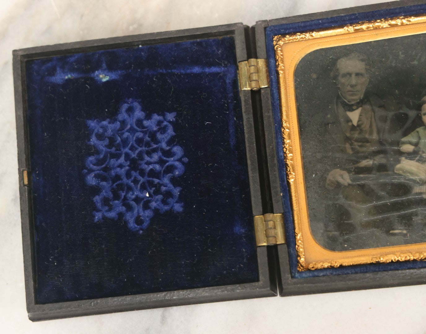 Lot 081 - Antique 1/6th Plate Tintype Photograph Of A Grandfather And Grand Daughter In Hand Tinted Green Dress, In Thermoplastic Union Case With Naval Ship Motif, Flag