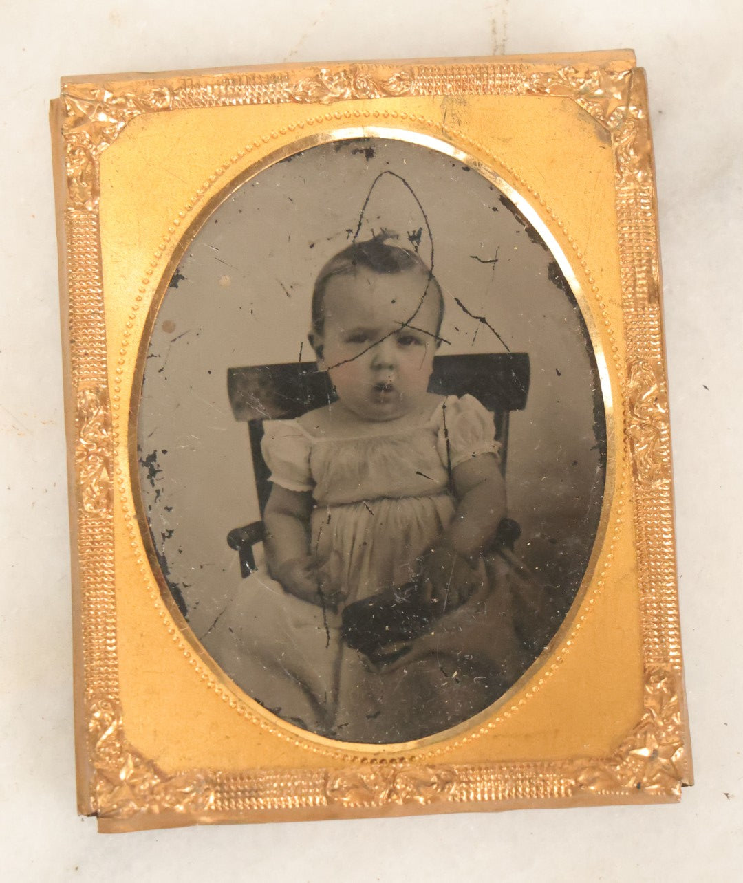 Lot 086 - Antique 1/9th Plate Ruby Ambrotype Photograph Of A Baby In A White Dress Seated In A Chair, Slack Jawed Expression, Note Scratches