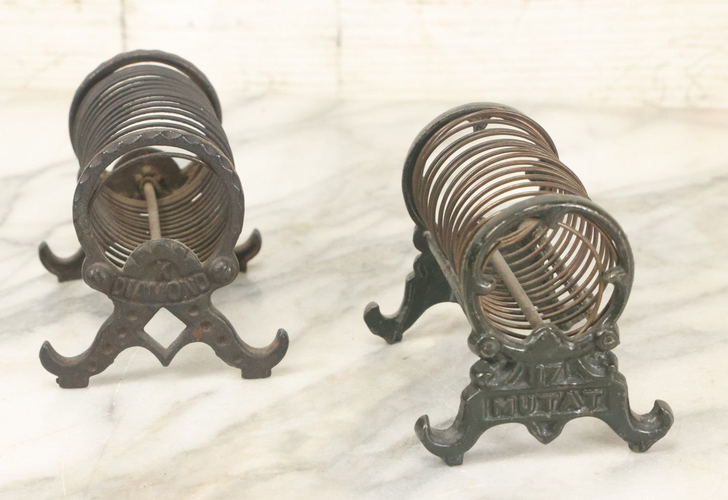Lot 071 - Pair Of Vintage Cast Iron Spring Coil Letter Holders With Legs, Boots, One By K. Diamond, One By Mutat, No. 17 In Old Green Paint