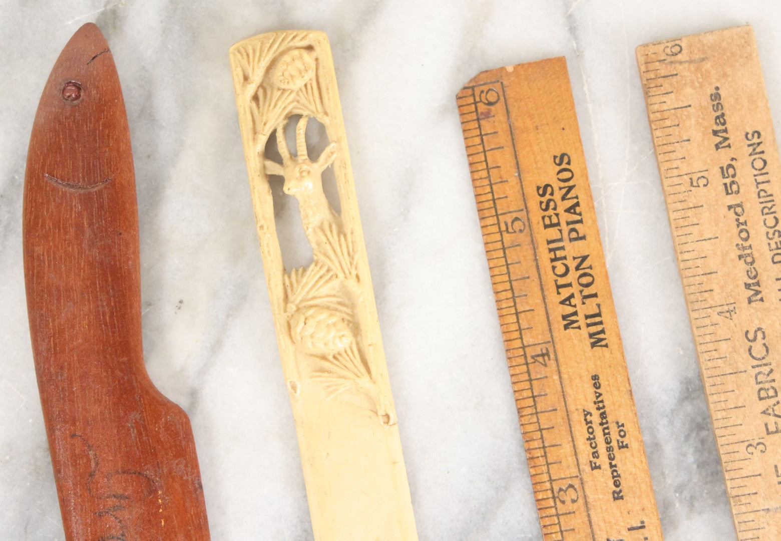 Lot 121 - Grouping Of Vintage Desk Tools Including Two Advertising Rulers, Carved Fish Letter Opener, And Celluloid Pronghorn Page Turner