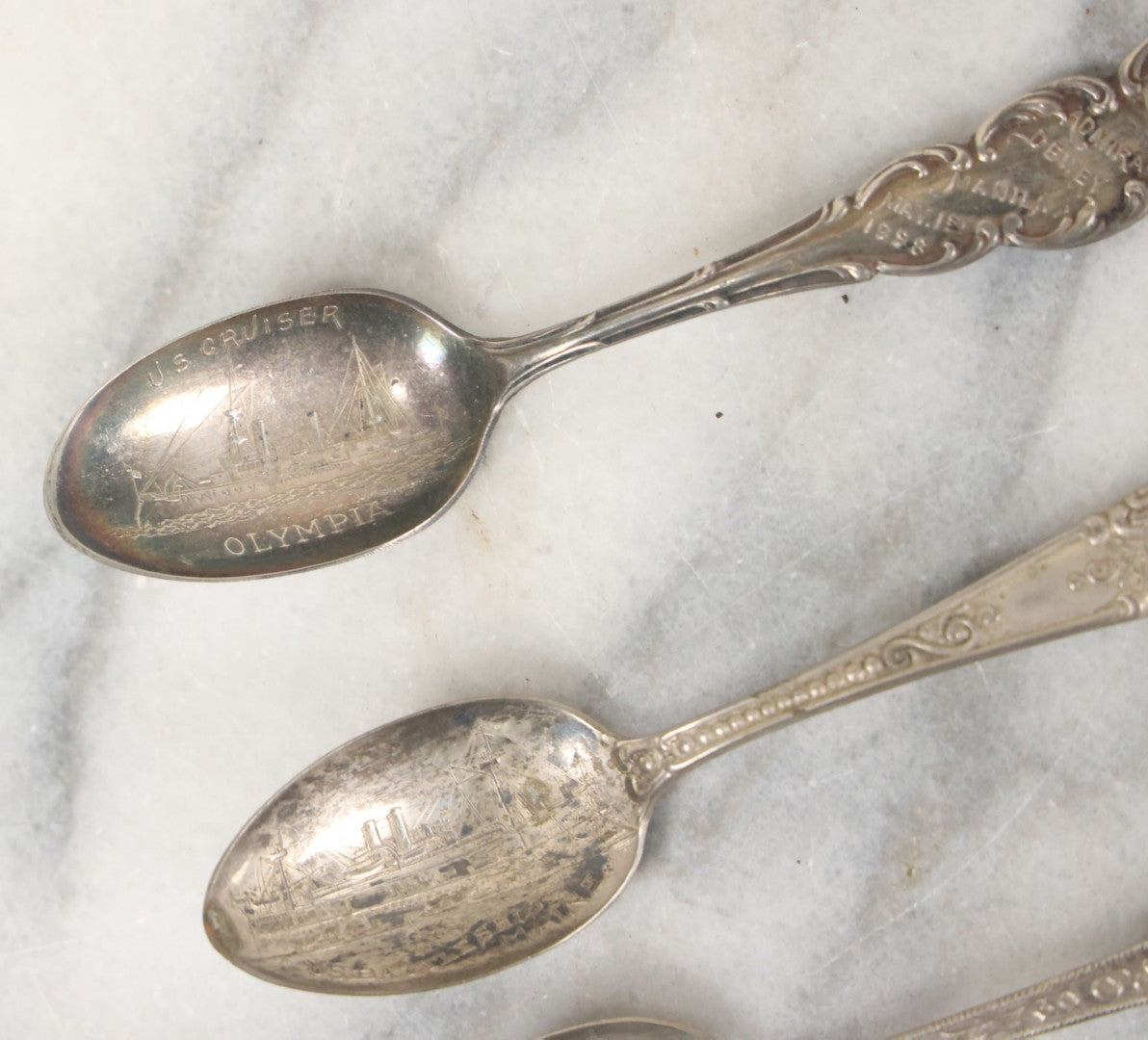 Lot 122 - Grouping Of 8 Antique Souvenir Spoons Relating To Ships And Leaders Of The Spanish American War Including The U.S. Battleship Maine, The Flagship New York, And Others, Manufactured By George E. Homer, Boston