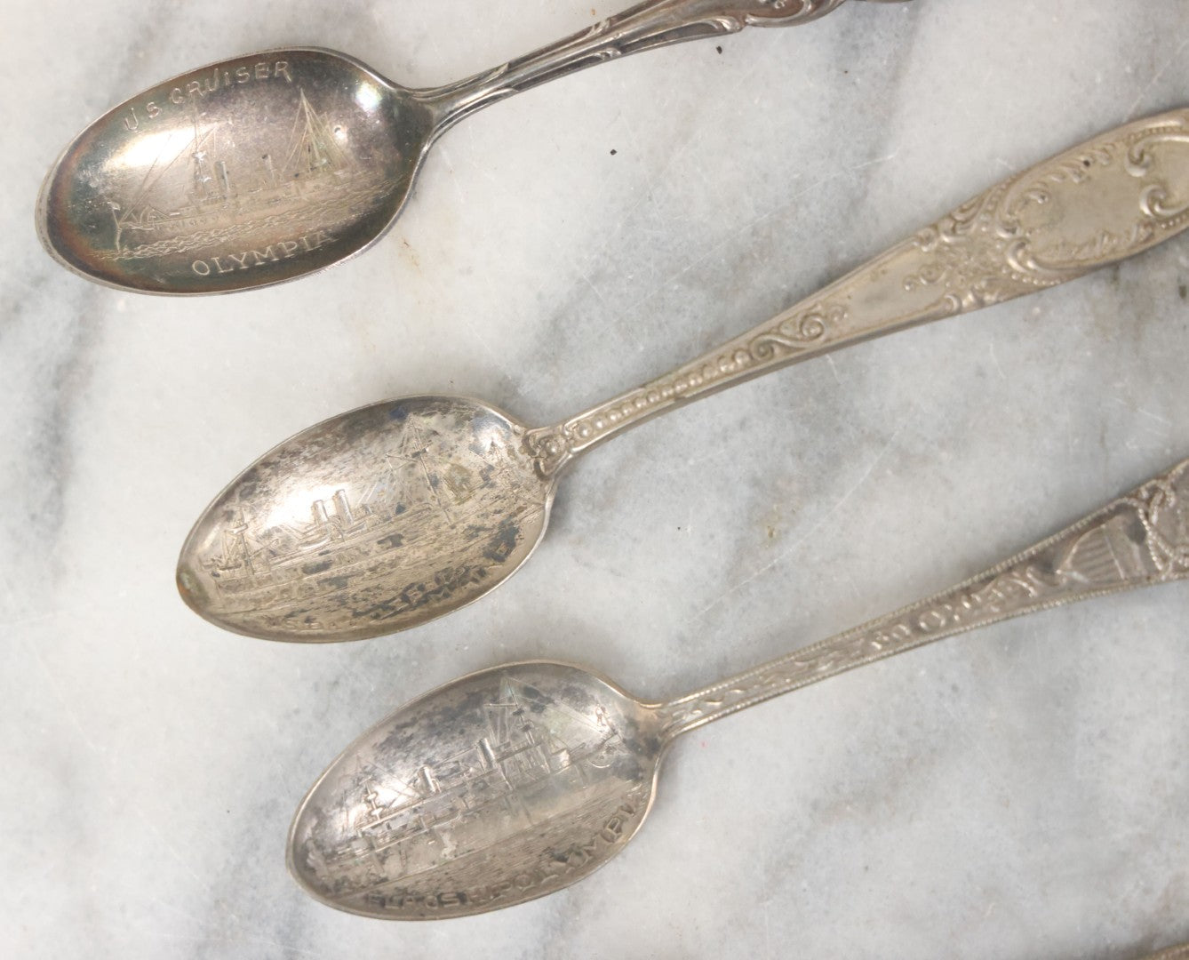 Lot 122 - Grouping Of 8 Antique Souvenir Spoons Relating To Ships And Leaders Of The Spanish American War Including The U.S. Battleship Maine, The Flagship New York, And Others, Manufactured By George E. Homer, Boston