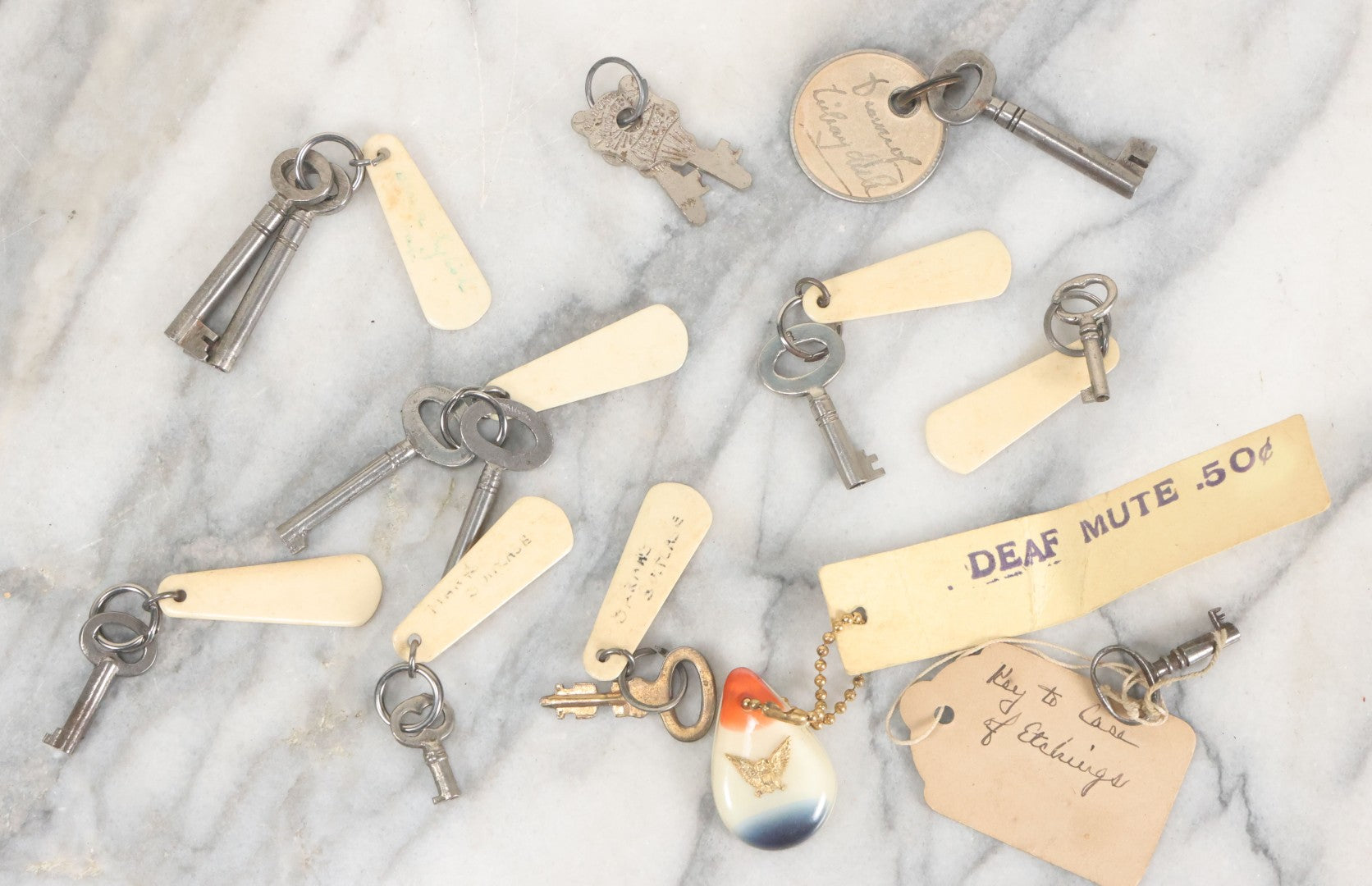 Lot 124 - Grouping Of 10+ Antique Furniture And Other Skeleton Keys With Custom Carved Bone Key Tag Keychains, Including Lucite Eagle Keychain Sold By A Deaf Mute Person