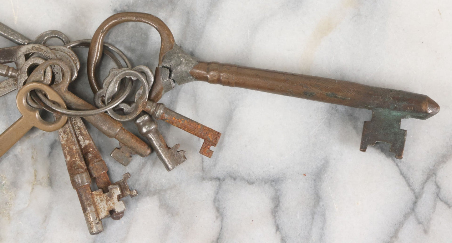 Lot 125 - Grouping Of 10+ Antique Skeleton Keys Including Two Large Gate Keys, Barrel Keys, And Others, Note One Large Key Has Crack