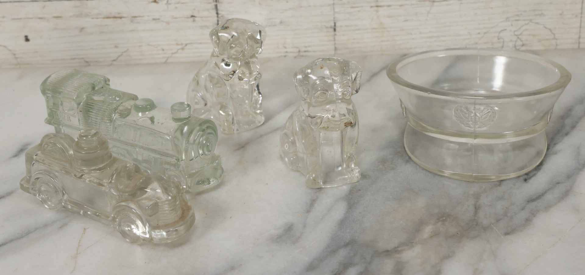 Lot 157 - Grouping Of Five Vintage Clear Glass Candy Containers Including Train, Firetruck, Two Dogs, And Military Cap Hat