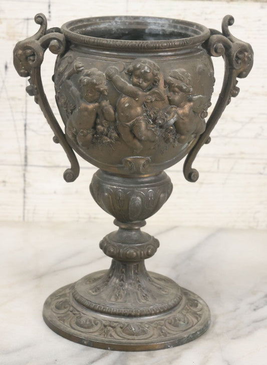 Lot 010 - Antique Ornate Cast Pot Metal Urn With Cherub And Goat Head Motifs, With Makers Mark On Bottom, Marked No. 1409, 9-1/2" High