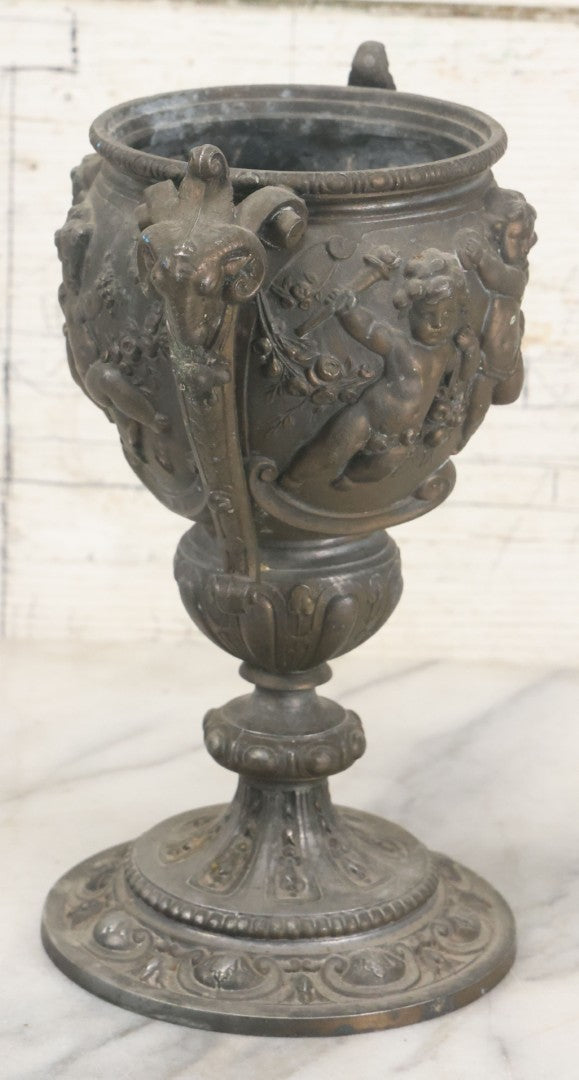 Lot 010 - Antique Ornate Cast Pot Metal Urn With Cherub And Goat Head Motifs, With Makers Mark On Bottom, Marked No. 1409, 9-1/2" High