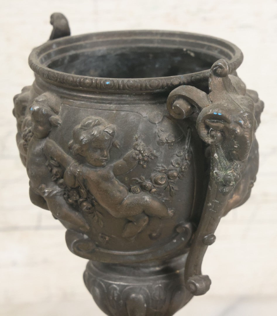 Lot 010 - Antique Ornate Cast Pot Metal Urn With Cherub And Goat Head Motifs, With Makers Mark On Bottom, Marked No. 1409, 9-1/2" High