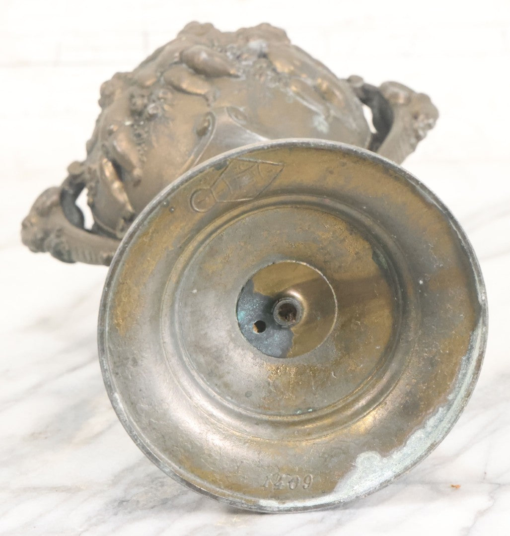 Lot 010 - Antique Ornate Cast Pot Metal Urn With Cherub And Goat Head Motifs, With Makers Mark On Bottom, Marked No. 1409, 9-1/2" High