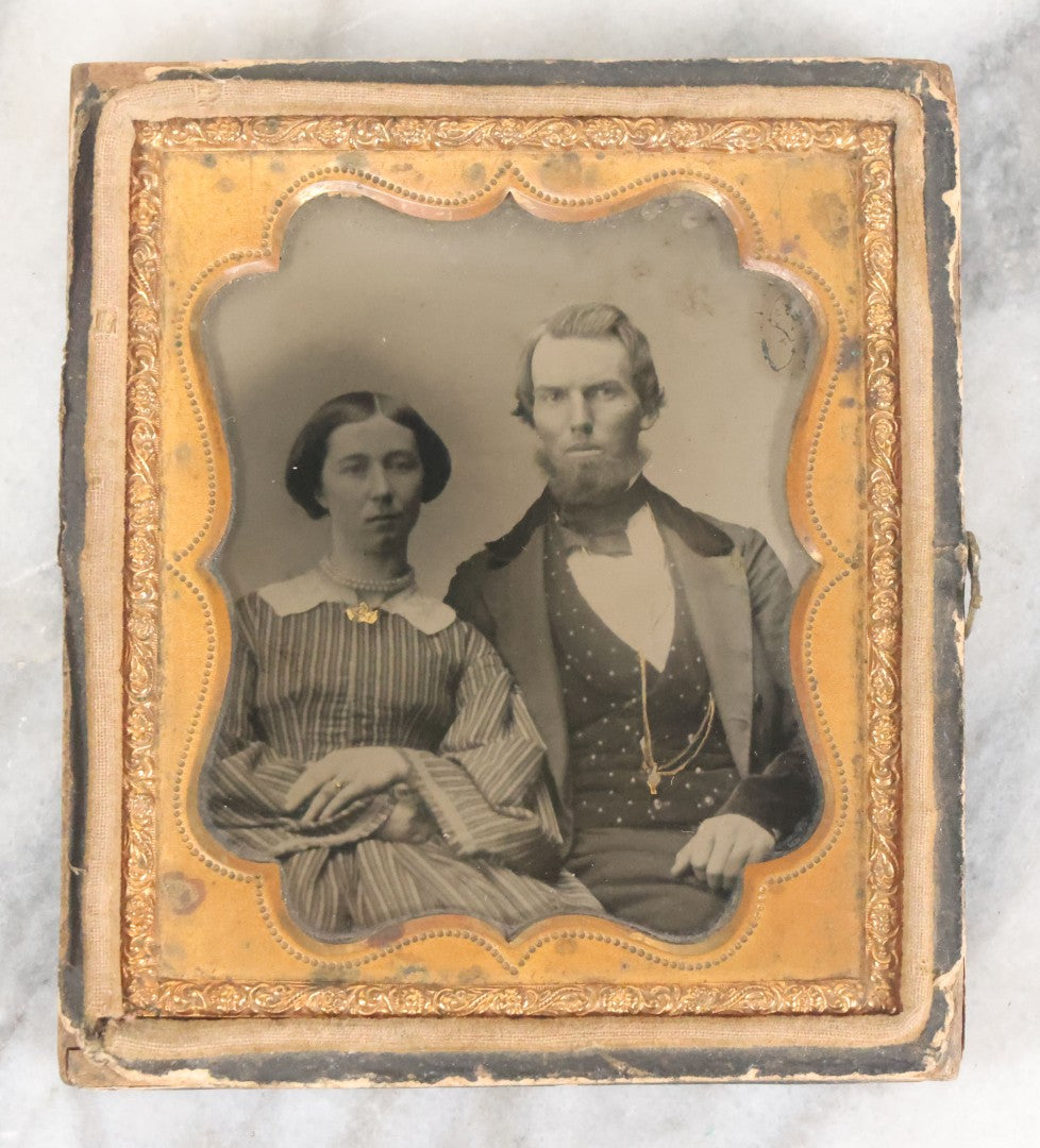 Lot 056 - Antique 1/6th Plate Ambrotype Photograph Of Young Couple Including Man With Messy Beard, Both With Gold-Tinted Jewelry, In Split Half Leatherette Union Case