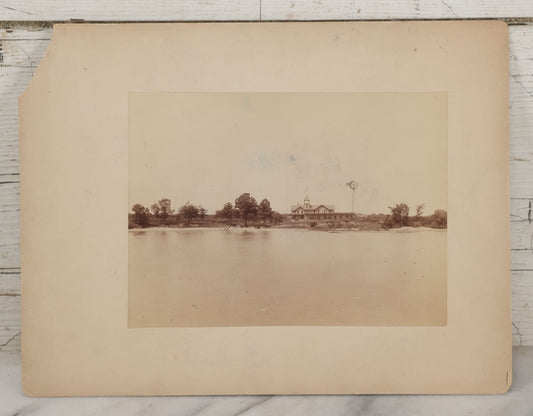 Lot 071 - Antique Boarded Photograph Of Farmhouse With Long Farmers Porch On Lakeside Flying American Flag With Windmill With "Ideal" Advertisement