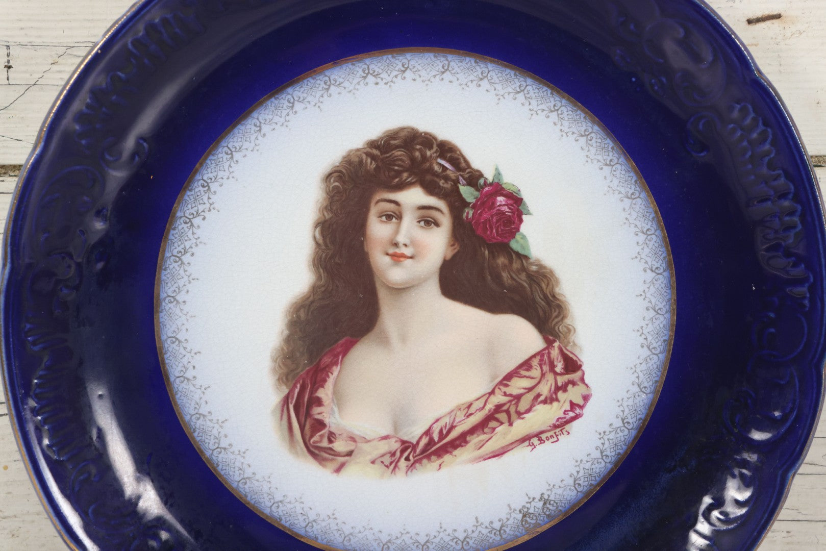 Lot 082 - Antique Decorative Transferware Plate With Blue Rim Featuring Pretty Woman With Long Brown Hair And Rose After G. Bonfits, By Royal La Belle, Wheeling Potteries Co., With Wire Hanger, 13" Diameter