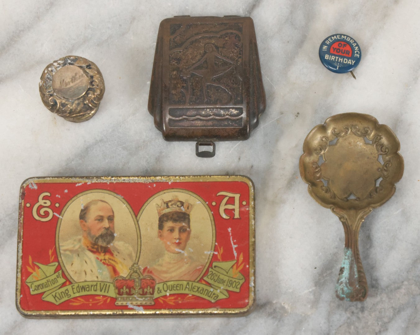 Lot 093 - Antique 5 Item Metals Grouping Including "Mother" Perfume Bottle Top, King Edward Vii & Queen Alexandra Commemorative Tin, Nude Woman Art Deco Fragment, First Birthday Pin, And Teaspoon