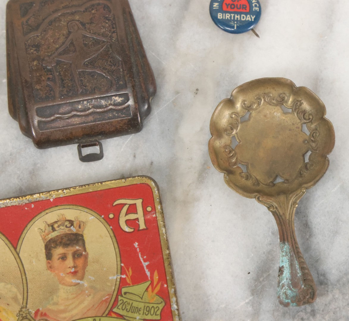 Lot 093 - Antique 5 Item Metals Grouping Including "Mother" Perfume Bottle Top, King Edward Vii & Queen Alexandra Commemorative Tin, Nude Woman Art Deco Fragment, First Birthday Pin, And Teaspoon