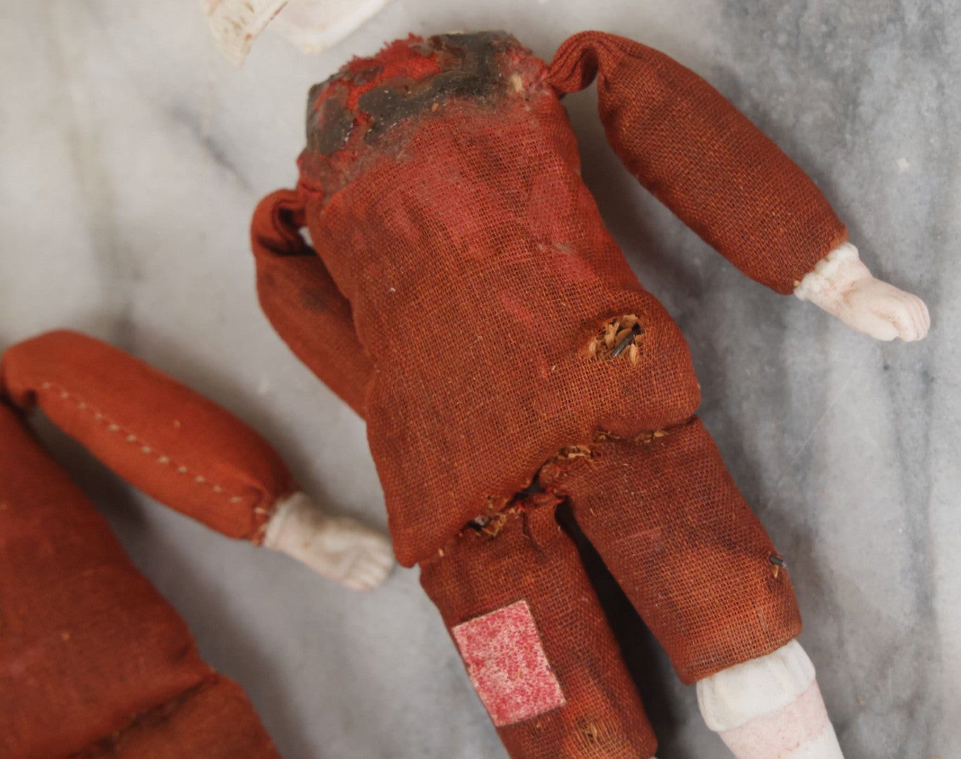 Lot 097 - Pair Of Antique Bisque Dolls With Boy And Girl With Blue Bows And Sawdust Filled Cloth Bodies, Note Girl's Head Detached, Holes In Bodies, With Sawdust Leakage, 6-1/4" Height Each