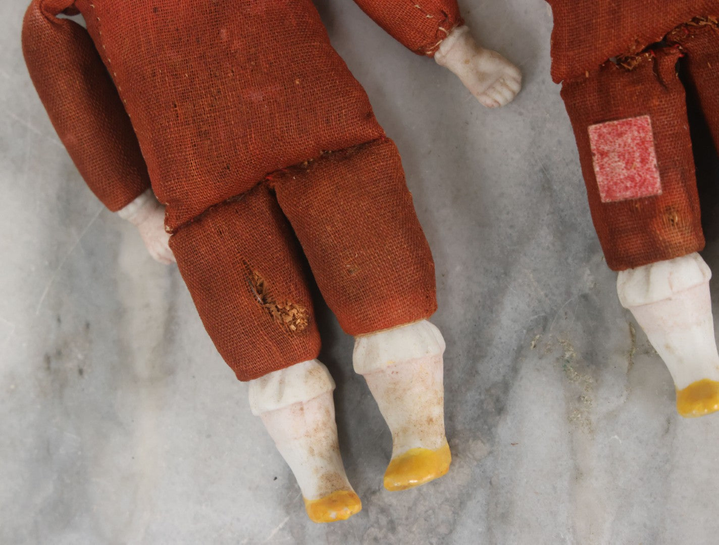 Lot 097 - Pair Of Antique Bisque Dolls With Boy And Girl With Blue Bows And Sawdust Filled Cloth Bodies, Note Girl's Head Detached, Holes In Bodies, With Sawdust Leakage, 6-1/4" Height Each