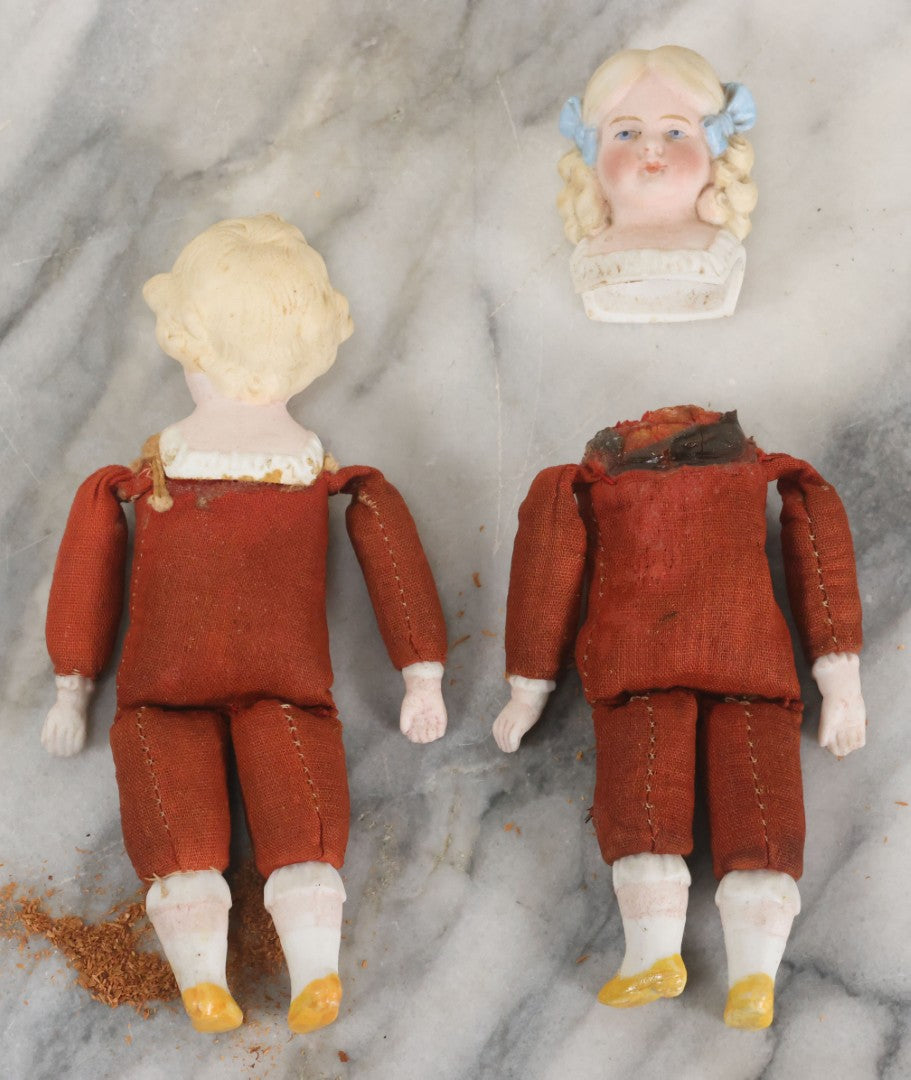 Lot 097 - Pair Of Antique Bisque Dolls With Boy And Girl With Blue Bows And Sawdust Filled Cloth Bodies, Note Girl's Head Detached, Holes In Bodies, With Sawdust Leakage, 6-1/4" Height Each