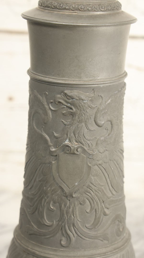 Lot 002 - Antique German Pewter Stein With Eagle, Griffin, And Cherub Motifs, Hinged Lid, Overall Height 14-1/4", Base 6-3/8" Diameter
