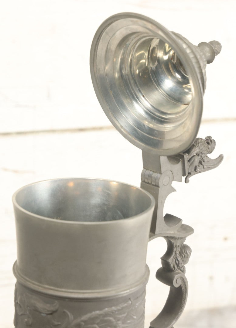 Lot 002 - Antique German Pewter Stein With Eagle, Griffin, And Cherub Motifs, Hinged Lid, Overall Height 14-1/4", Base 6-3/8" Diameter